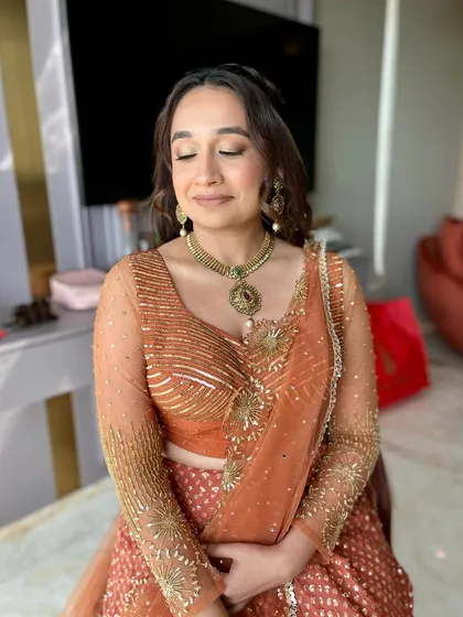 A gorgeous look for a Garba evening. The rust-colored lehenga is paired with a warm, bronzy makeup look and defined eyes.