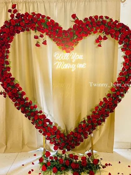 We love creating unforgettable proposal moments. This giant heart-shaped arch made entirely of fresh red roses, complete with a custom "Will You Marry Me" neon sign, makes for a definite yes.
