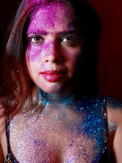 A clean and striking beauty shot of the glitter makeup. Her expression is confident, and the colors are vibrant and captivating.