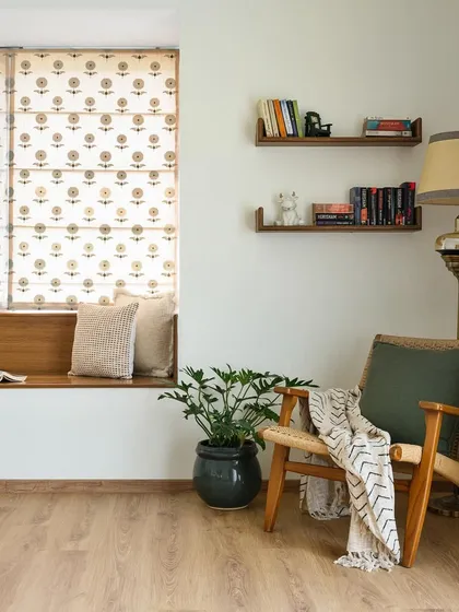 A cozy reading nook in the 'House of Kismish' primary room, featuring a built-in window seat. This space is perfect for quiet moments, complemented by floating shelves for books and decor.