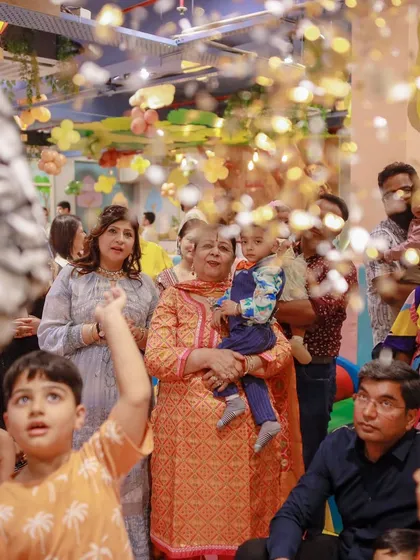 Guests watch in awe during a magic show at the dinosaur-themed party. The combination of prehistoric decor and magical entertainment creates a unique experience.
