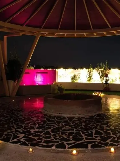 Another view of the outdoor fire pit area at night, with the water feature and lighting creating a magical and tranquil ambiance for evening programs.