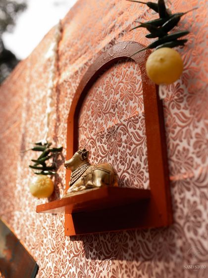 Another detail from the band backdrop, showcasing a small brass Nandi statue nestled in a wooden frame. This subtle nod to tradition was placed alongside a 'nimbu mirchi' for blessings and protection.