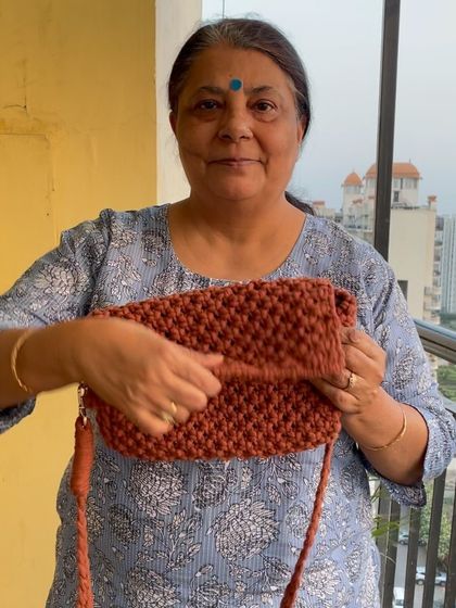 A rust-colored macrame bag, perfect for adding a warm tone to your look. Each bag is a testament to the laborious yet rewarding art of macrame.