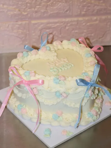 The full view of our heart-shaped baby shower cake, a beautiful and classic design to welcome "Baby Shah."