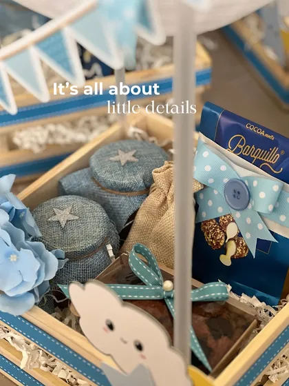 It's all about the little details. A close-up of the celestial-themed hamper, filled with treats and decorated with cute cloud and moon cutouts and blue floral accents.
