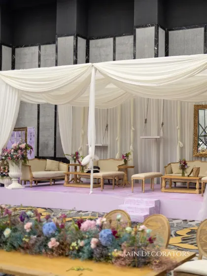 A serene and sophisticated lounge area. I used soft white drapes to create a canopy over plush seating, all set on a lavender stage for a look that is both calming and incredibly chic.
