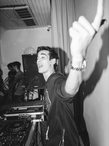 A candid black and white shot capturing a moment of pure joy behind the decks. This is what it looks like when you truly love what you do.