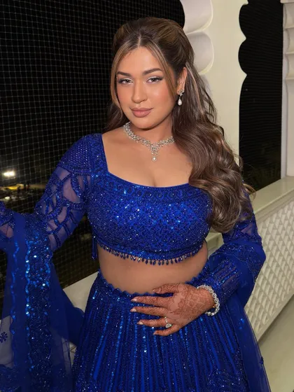 The complete look. The soft waves in her hair and the radiant makeup come together for a perfect sangeet night appearance.