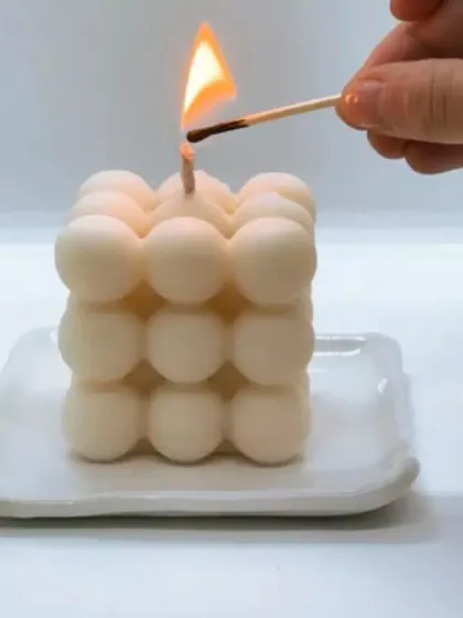 Lighting a classic white bubble candle. You can order these in over 10 different fragrances to fill your home with your favorite scent.