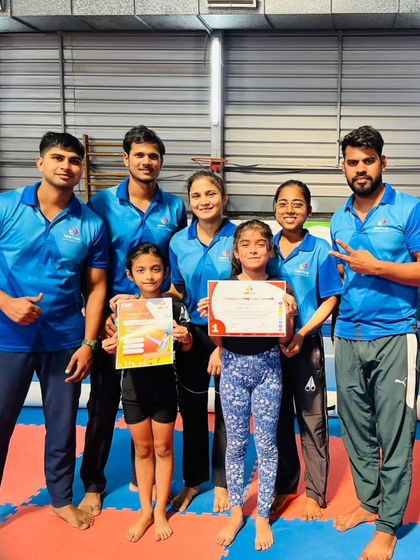 Our coaching team stands proudly with two of our certified students.