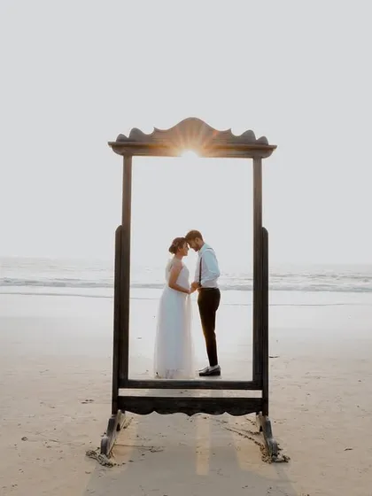 A creative pre-wedding concept on the beach. Using props like this vintage mirror allows us to play with reflections and framing, creating artistic and unique couple portraits against the serene ocean backdrop.