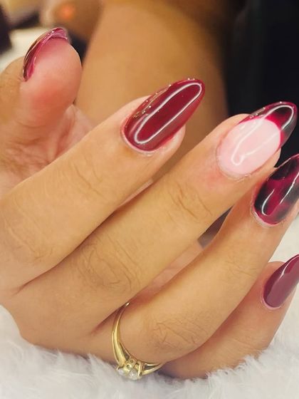 A close-up of this stunning tortoiseshell nail art. The glossy finish enhances the depth of the black and deep red pattern, creating a luxurious effect.