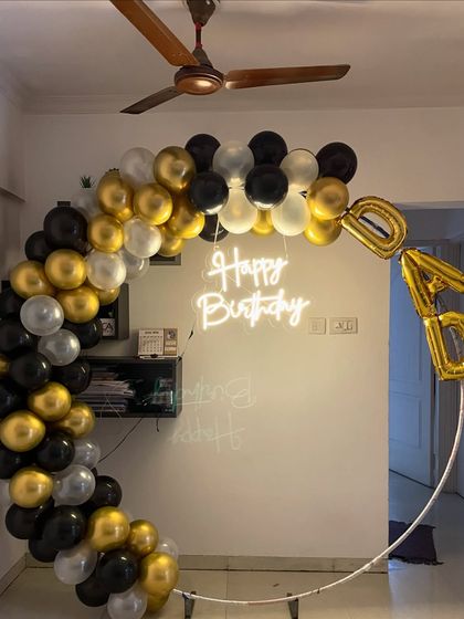 A classic ring arch for a dad's birthday celebration. The black, gold, and silver balloon arrangement with a central neon sign is a timeless and stylish choice for honoring a loved one.