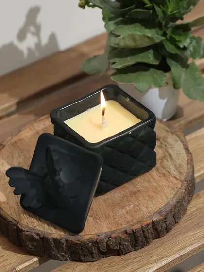 Our minimal black scented candle with a quilted texture and a butterfly-adorned lid. Paired with a rustic wood slice, it’s an experience of clean lines, warm scents, and a hint of shimmer.