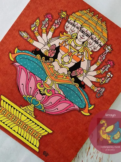 The completed Sri Gayatri Devi painting on a 12x14 inch canvas. The vibrant colors against the textured orange background highlight her divine, multi-faceted form, seated gracefully on a lotus.