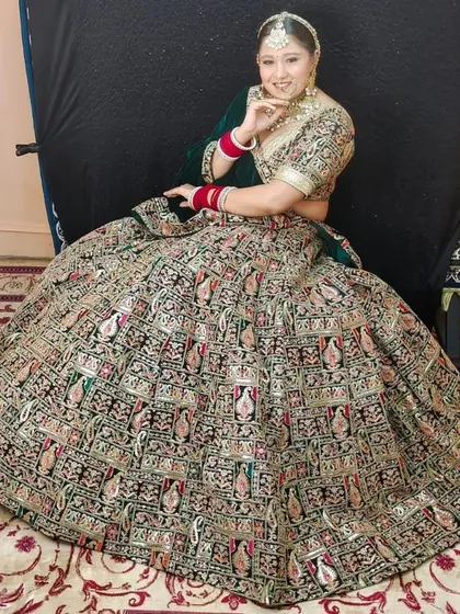 This dark green lehenga has a massive flare, covered in intricate traditional prints. It's a statement piece that is sure to turn heads.
