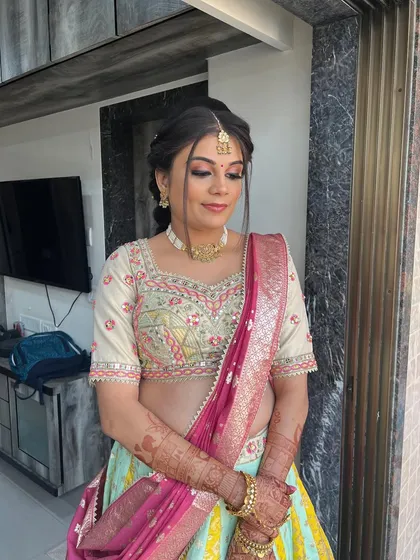 A full view of this lovely baby shower look, with a pastel lehenga and a neat updo.