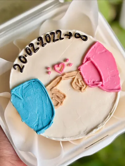 A bento cake celebrating a special date with a pinky promise illustration. The design uses minimal lines and color to create a modern and meaningful message.