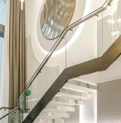 A detail of the floating staircase in the Vikaspuri residence, with its white marble steps and a striking metallic art installation on the wall.