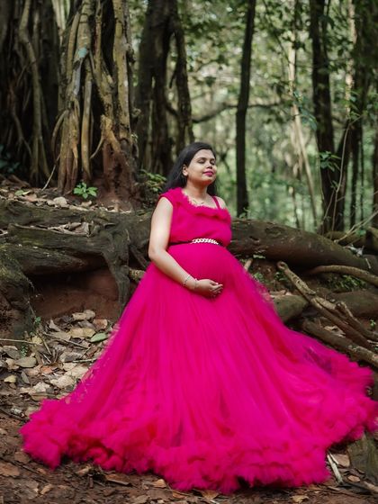 The long, ruffled train of this magenta gown looks stunning in a woodland setting. It's designed to add drama and elegance to your maternity photos.
