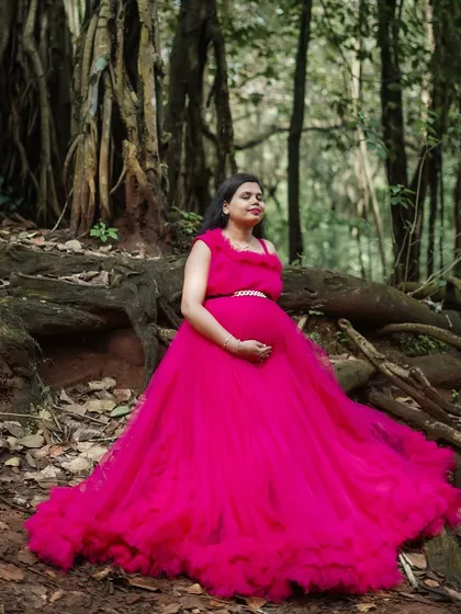 The long, ruffled train of this magenta gown looks stunning in a woodland setting. It's designed to add drama and elegance to your maternity photos.