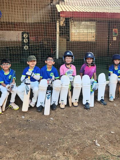 Our young cricket squad, fully kitted out and ready for action. This image shows them seated with their bats and pads, representing the next generation of players learning the ropes with us.