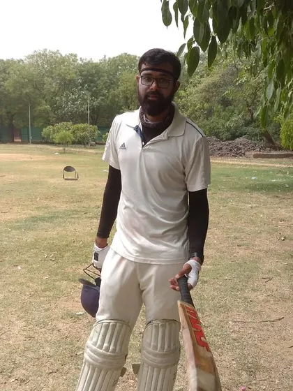 A batsman padded up and ready to go, holding his bat. This image captures the anticipation and readiness that every player feels before walking out to the crease.
