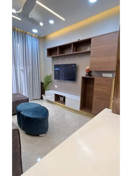 A look at the completed 3BHK interior project in Gurgaon. This is the living room, featuring a custom TV unit with open shelving and concealed storage.
