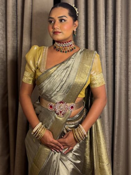 A full look in a beautiful grey and gold Kanjivaram-style saree. This ensemble is perfect for hosting a traditional wedding ceremony or reception.