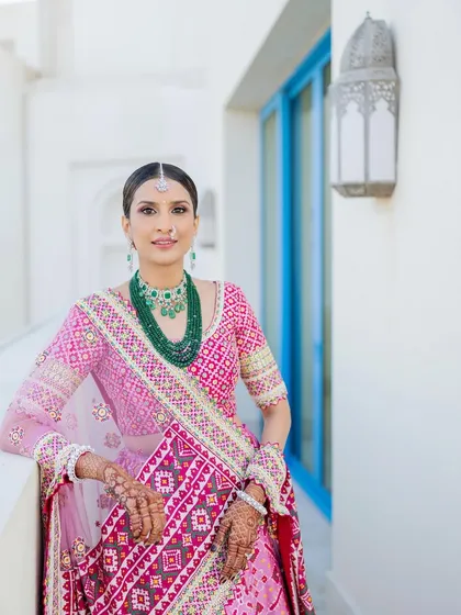 A stunning portrait that captures the elegance of the look. The makeup is designed to enhance her features and create a timeless beauty that is perfect for a royal wedding celebration.