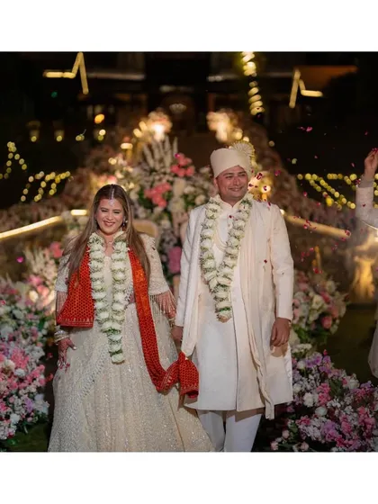 A moment of pure happiness as the newlyweds walk hand-in-hand down the aisle at their Mussoorie wedding. The smiles on their faces are illuminated by the warm glow of the lights, surrounded by friends, family, and flowers.