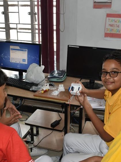 Two students proudly display the sensor component they are working with. This image captures the excitement of discovery and accomplishment in our workshops.
