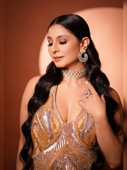A close-up of Tanishaa Mukerji in a stunning golden gown. This shot highlights the glamorous makeup, with a focus on the eyes, and the intricate diamond choker and earrings.