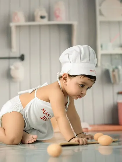 Even our little chefs get adventurous. This action shot captures a baby on the move, exploring the props and set during a playful moment in our Master Chef session.