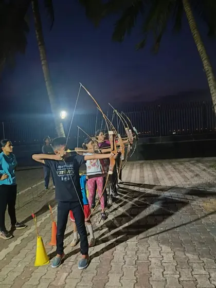 A coach guides a young student during a night session at the summer camp.