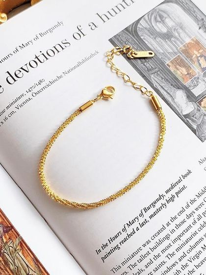 A close-up product shot of my shimmering gold-tone bracelet, showing the adjustable clasp and high-quality stainless steel material.