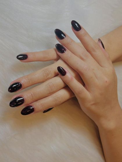 Bold and dramatic. These glossy, deep black cherry nails are perfect for making a statement. The almond shape adds to the elegant and powerful look.