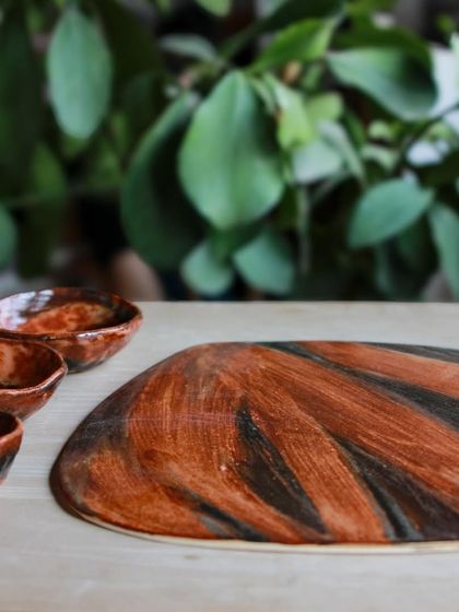Another view of the festive platter and dip bowls, showcasing their organic shape and the rich, layered colors of the glaze.