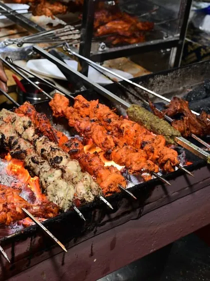 The heart of our kitchen is the sigdi, where the magic happens. Here you can see our chefs grilling fresh tandoori chicken and seekh kebabs over hot coals. This live BBQ station ensures every dish is served hot, smoky, and full of flavour.