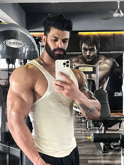 A quick progress check at the gym. My muscle gain programs are designed to create significant size and vascularity, focusing on key areas like shoulders and arms for a balanced aesthetic.
