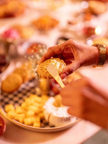 Spreading some butter on our savory Mathri shortbread, a perfect accompaniment to a festive cheese board.