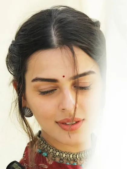 A delicate and ethereal portrait, using a sheer fabric to partially obscure the face. This technique adds a layer of mystery and softness to the image.