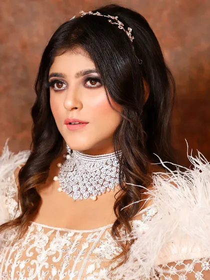 This client is wearing a modern diamond-look choker with pearl drops, paired with a feathered party wear outfit. A perfect combination for a glamorous evening.