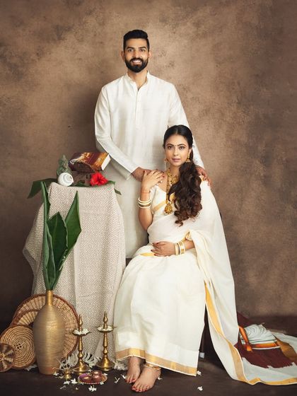 A formal portrait of the couple in their serene white traditional outfits. This shot has the feel of a classic painting, elegant and full of grace.