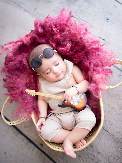 A sleeping baby rockstar, dreaming of his first hit single. A creative and fun shot for a baby boy.