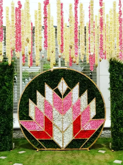 A close-up of the circular floral lotus backdrop, showing the geometric pattern created with white, pink, and red petals.