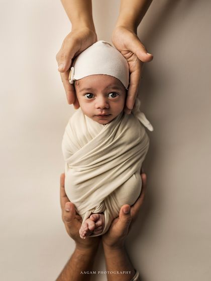 Precious little one in safe hands. This creative shot shows a newborn being held by both parents' hands, emphasizing how small and protected they are.
