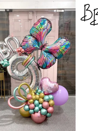 An enchanted bouquet for a 9th birthday. This arrangement features a stunning iridescent butterfly balloon, a silver number '9', and a mix of pastel and metallic balloons for a truly magical look.