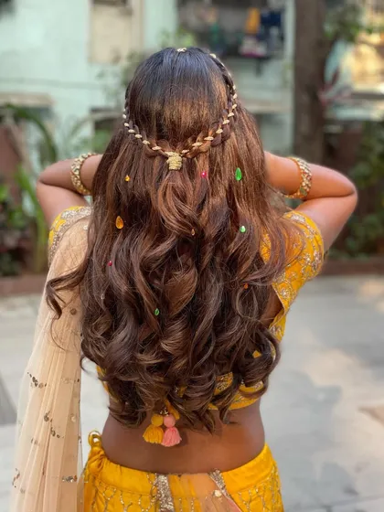 The back view of this creative and festive hairstyle. The gotta patti and colorful accents are perfect for a Haldi or Mehendi ceremony.
